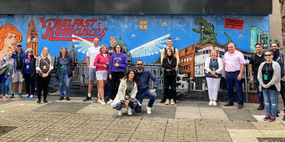 Visitors in front of the Belfast Romances mural